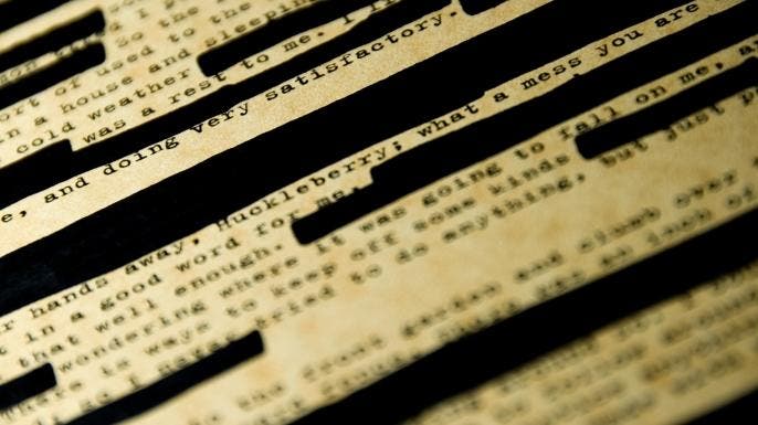 A page of Huckleberry Finn with redacted passages.
